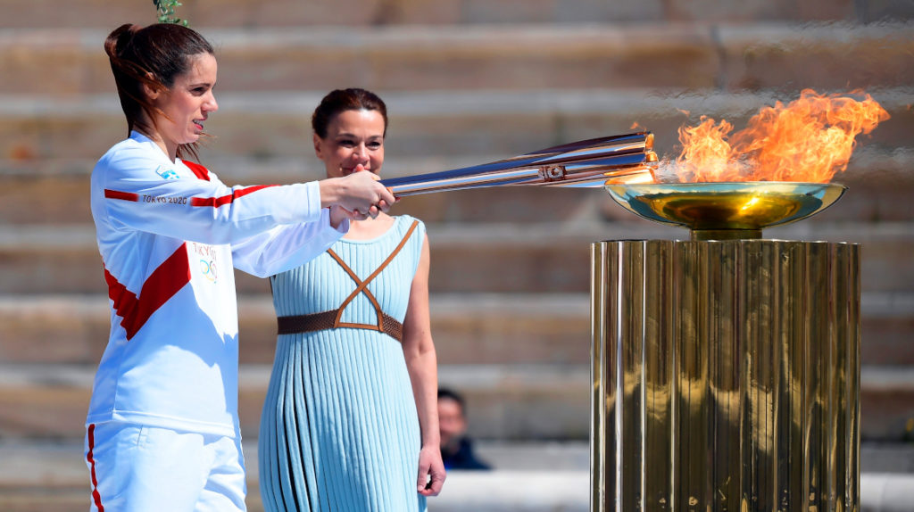 Athens (Greece), 19/03/2020.- Greek pole vaulter Katerina Stefanidi (L), Olympic gold medallist and world champion, lights the Olympic torch during the Olympic Flame handover ceremony for the Tokyo 2020 Summer Olympic Games at the Panathenaic Stadium in Athens, Greece, 19 March 2020. (Salto con pértiga, Grecia, Atenas, Tokio) EFE/EPA/ARIS MESSINIS / POOL
